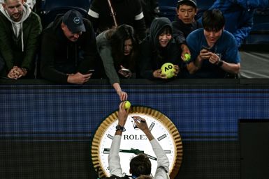 Russia's Daniil Medvedev signs autographs above the clock on Rod Laver Arena