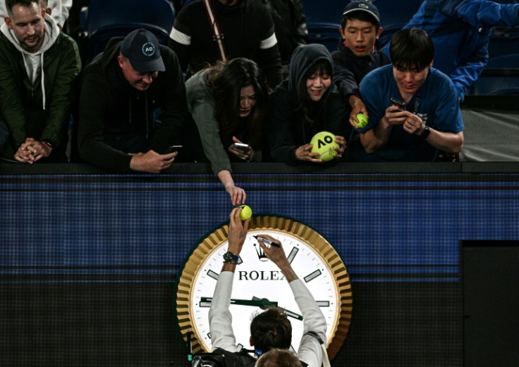Russia's Daniil Medvedev signs autographs above the clock on Rod Laver Arena