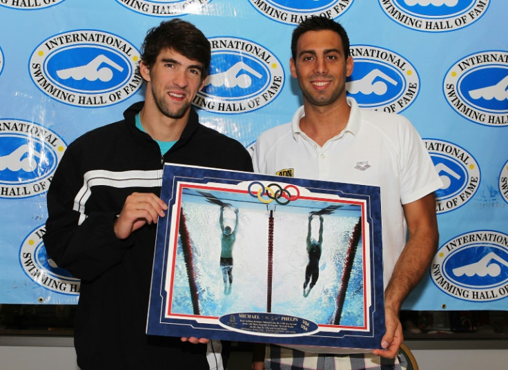 US swim star Michael Phelps, left, and Milorad Cavic hold a famous Sports Illustrated photo of their 100m butterfly photo finish, in which Phelps won gold at the 2008 Olympics, a sign of the iconic nature of the magazine which had its staff fired