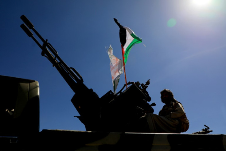 A Yemeni supporter of the Huthi movement sits on the back of an armored vehicle during an anti-Israel and anti-US rally in Sanaa