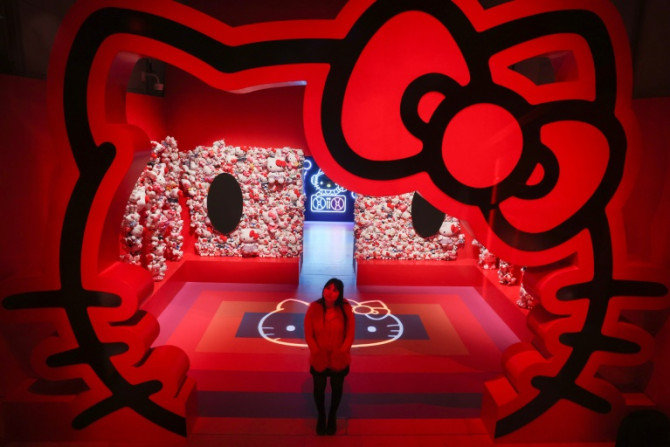 A gallery employee poses next to a Hello Kitty installation during a photocall of the exhibition "CUTE" at the Somerset House, central London, on January 24, 2024. CUTE is the first major exhibition to examine the extraordinary and complex power of cutene