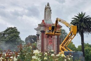 A worker cleans a statue of Britain's Queen Victoria that was defaced in Melbourne on Thursday