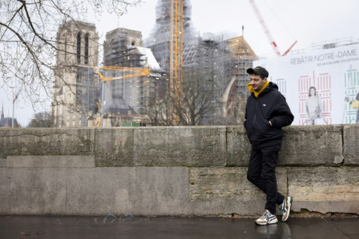 Thomas Jolly poses in front of the rebuilding works at Notre Dame Cathedral, which was damaged by fire in 2019