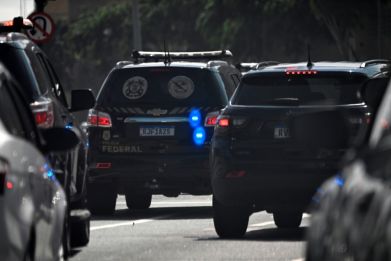 Brazilian police drive to federal headquarters after conducting a raid on the house of councilman Carlos Bolsonaro in Rio de Janeiro