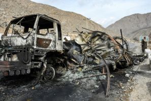 A man walks past a truck torched by militants during an hours-long battle in Bolan district, Balochistan province