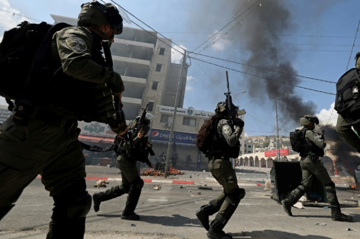 Israeli security forces deploy while clashing with Palestinians during the funeral of 19-year-old Labib Damidi, who was shot dead by settlers in the occupied West Bank town of Huwara on October 6, 2023