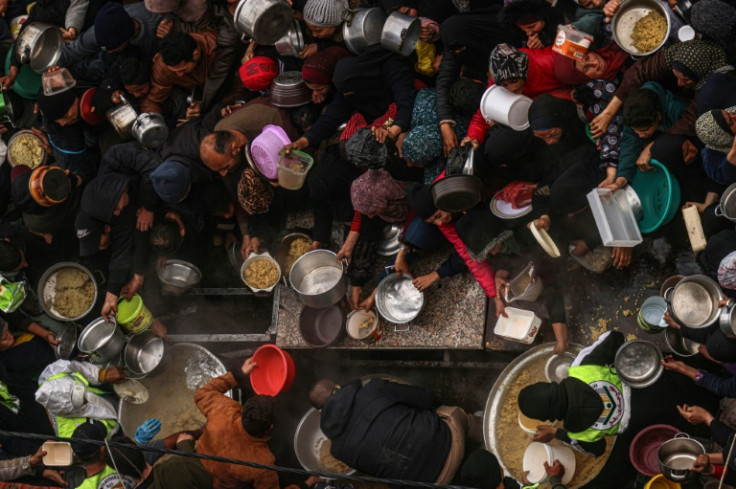 Palestinians receive food rations at a donation point in the city of Rafah, where half of the Gaza Strip's population is now living