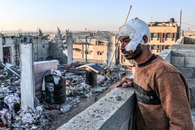 An injured man looks on while standing next to the rubble of a destroyed building following an Israeli bombardment in Rafah
