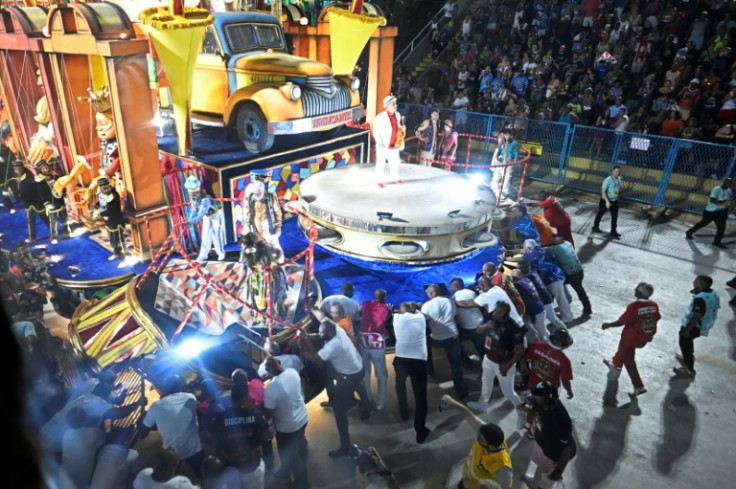 Workers at Rio de Janeiro's Carnival parade help after a car accident during the performance of the Porto da Pedra samba school