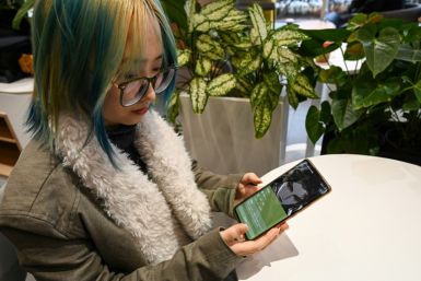 Wang Xiuting talks to her virtual boyfriend on Wantalk - an artificial intelligence chatbot created by Chinese tech company Baidu, on her phone at a cafe in Beijing
