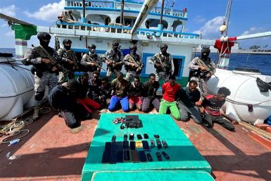 Indian commandos stand guard over Somali pirates who kidnapped an Iranian fishing vessel off the Somali coast,  on January 30