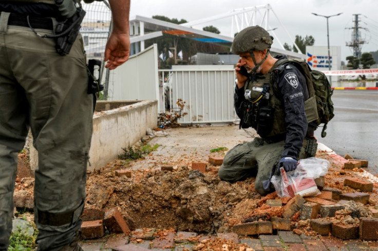 An Israeli policeman inspects the impact crater left by a rocket fired from southern Lebanon in the northern city of Safed