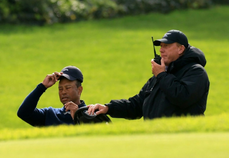 Golf superstar Tiger Woods speaks with a rules official after withdrawing from the Genesis Invitational because of illness