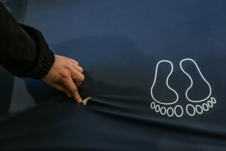 A nurse shows a bullet hole left in a mattress after the Israeli raid on the hospital