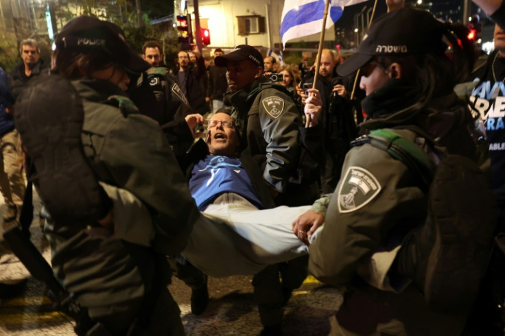 Israeli security force members arrest a protester in Tel Aviv where thousands called for early elections and accused the government of abandoning hostages held in Gaza