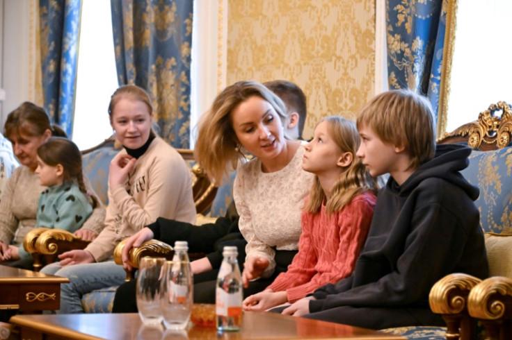 Russia's presidential commissioner for children's rights Maria Lvova-Belova talks with Ukrainian children before  they return home under a deal brokered by Qatar