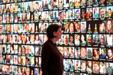Raquel Ukeles of Israel's national library looks at a screen bearing the portraits of Israelis killed during the October 7 attack