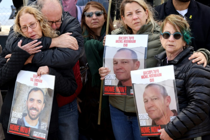 Relatives of Israeli hostages held by Gaza militants carry pictures of them in Kibbutz Nirim