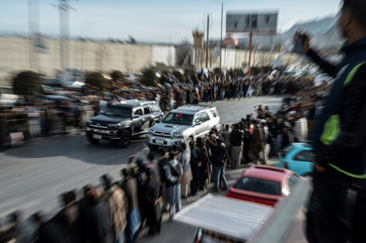 Spectators watch modified cars compete in a drag race along a street during a car racing event in Kabul