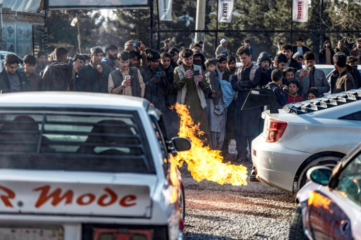 Taliban authorities policed the hundreds-strong crowd that jostled along a blocked off main Kabul road for the first drag races of the Victory Cup event, sometimes swinging sticks to push back eager spectators