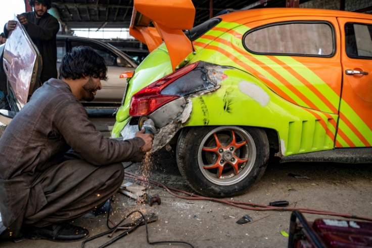 An Afghan mechanic works on a modified car at a specialized workshop in Kabul