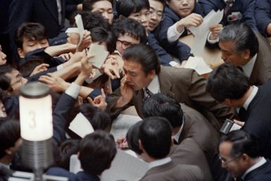 Floor traders jostle on January 7, 1988 as stock prices soar on the Tokyo Stock Exchange following the sharp rise in the yen against the dollar