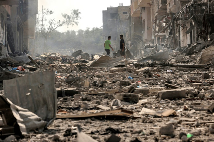 Men walk through debris in a bombed-out street of the Jabalia refugee camp