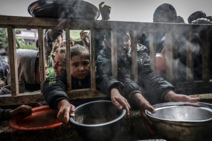 Displaced Palestinian children gather to receive food in Rafah on February 19