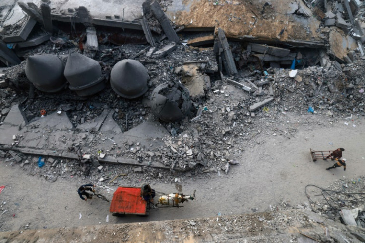 A donkey-pulled cart passes in front of the Al-Faruq mosque, levelled by Israeli bombardment in Rafah