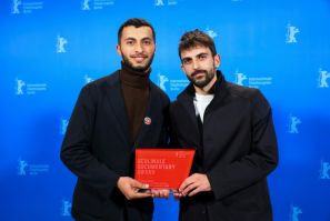 Basel Adra, left, was applauded when receiving the Berlin Film Prize, when he said the Gaza population was being 'massacred'