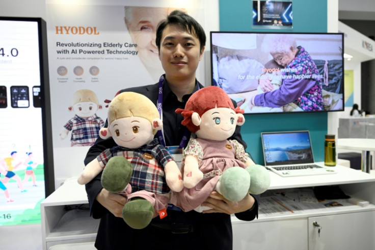 An employee of South Korean company Hyodol holds AI-powered dolls meant to provide companionship to elderly people