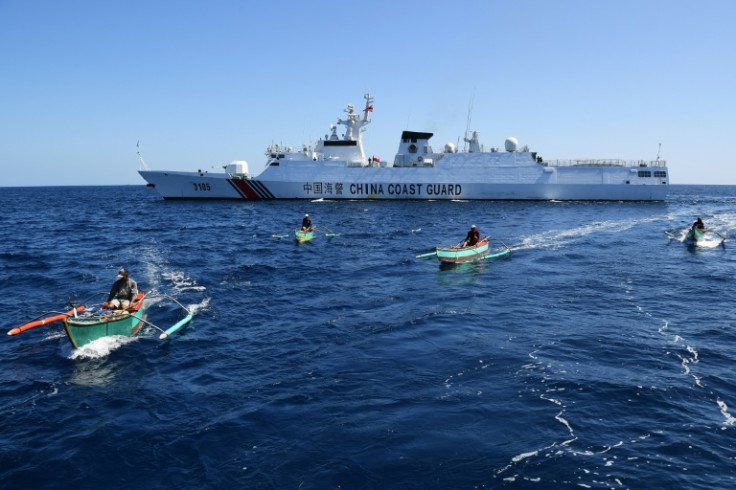 Filipino fishermen sail past a Chinese coast guard ship near the Scarborough Shoal, which has been a flashpoint between the countries since China seized it from the Philippines in 2012