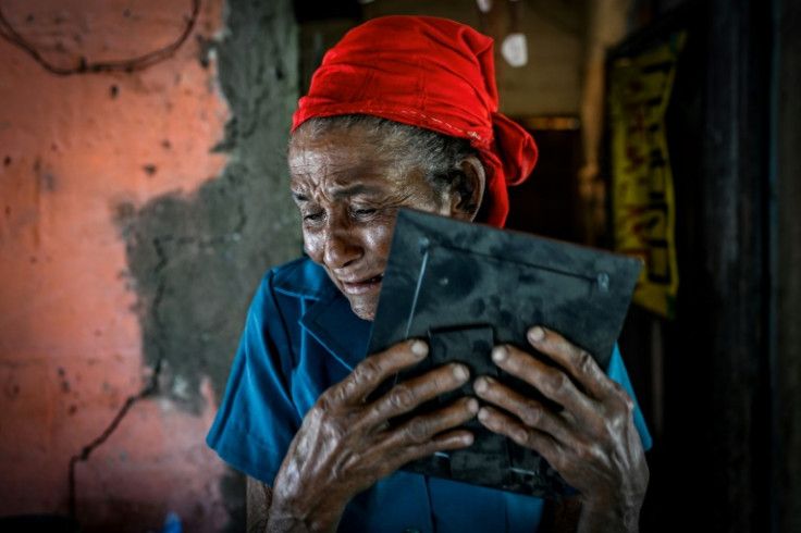 Soledad Ruiz wipes tears away as she clutches a composite sketch of her son, Apolinar, who was 25 when he left for work on a farm in San Onofre in northern Colombia in 1999, never to be seen again