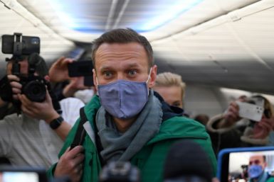 Russian opposition leader Alexei Navalny and his wife Yulia walk to take their seats in a Pobeda plane heading to Moscow from Germany on January 17, 2021