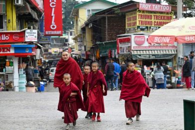Buddhist monks walk down a street in McLeod Ganj near Dharamsala on February 18, 2024