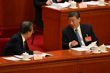 National People's Congress Chairman Zhao Leji (L) speaks to President Xi Jinping at Friday's plenary session