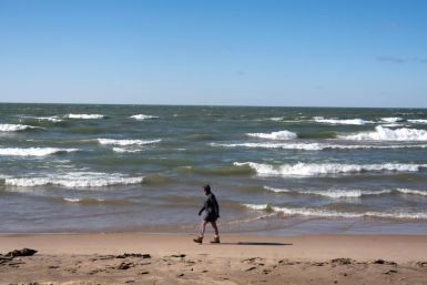 A woman walks along the Lake Michigan shoreline in February in Whiting, Indiana; the Great Lakes shorelines have historically been ice-covered this time of year