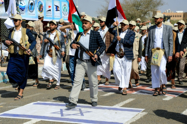 Yemenis step on Israeli and British flags as they take part in a parade in the Huthi-run capital Sanaa on March 9