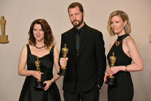 Ukrainian filmmaker Mstyslav Chernov, centre,  with his Oscar alongside producers Raney Aronson-Rath, left, and Michelle Mizner