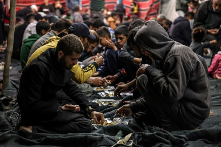 Palestinians share an iftar meal on the first day of the Muslim holy month of Ramadan at a camp for displaced people in Rafah