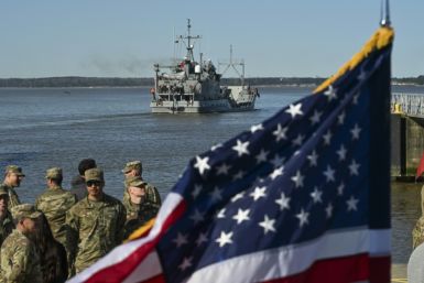 US Army soldiers stand near an American flag as the USAV Wilson Wharf departs for an operation to construct a temporary port on Gaza's coast for the delivery of urgently needed aid