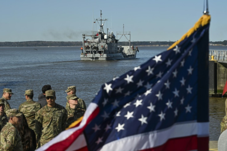 US Army soldiers stand near an American flag as the USAV Wilson Wharf departs for an operation to construct a temporary port on Gaza's coast for the delivery of urgently needed aid