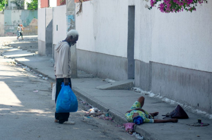 A man tires to help an elderly woman, who was shot on her foot, in Port-au-Prince, Haiti, on March 9, 2024
