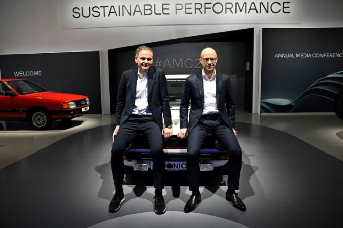 Volkswagen CEO Oliver Blume and finance chief Arno Antlitz pose on a car