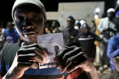 A demonstrator holds a picture of Senegalese presidential candidate Bassirou Diomaye Faye as he celebrates Faye's and opposition leader Ousmane Sonko's release from prison, near Cap Manuel prison, in Dakar