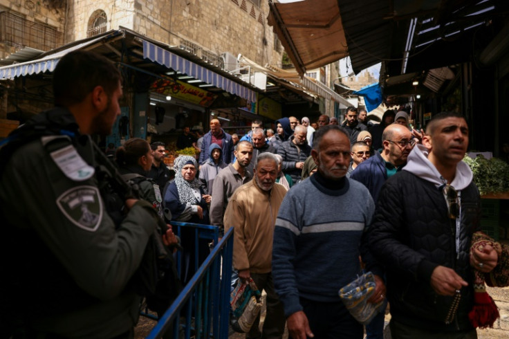 Palestinians enter the mosque compound from the alleyways of Jerusalem's walled Old City under the watchful eye of Israeli security personnel
