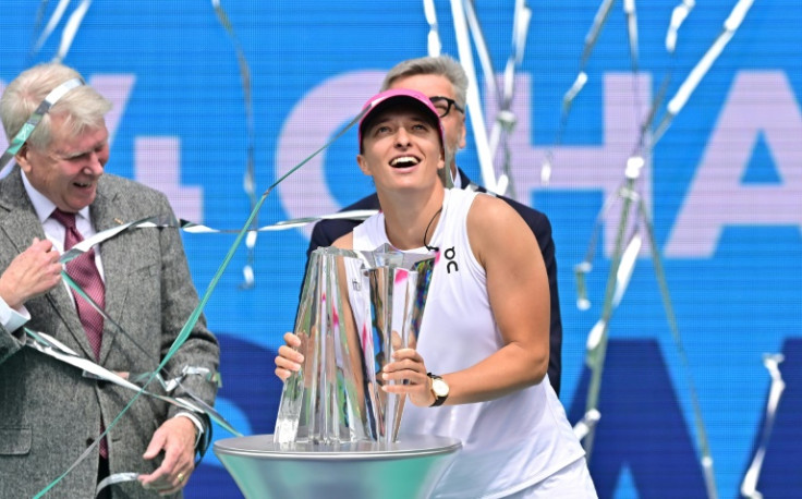 Poland's Iga Swiatek reacts as confetti flies while she receives her Indian Wells WTA trophy after a win over Maria Sakkari in the championship match