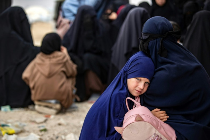 A girl hugs her mother at the al-Hol camp in Syria where the families of IS fighters are held