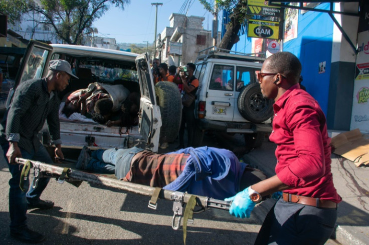 Paramedics carry the body of a person killed by gang members in Petionville, Port-au-Prince, Haiti