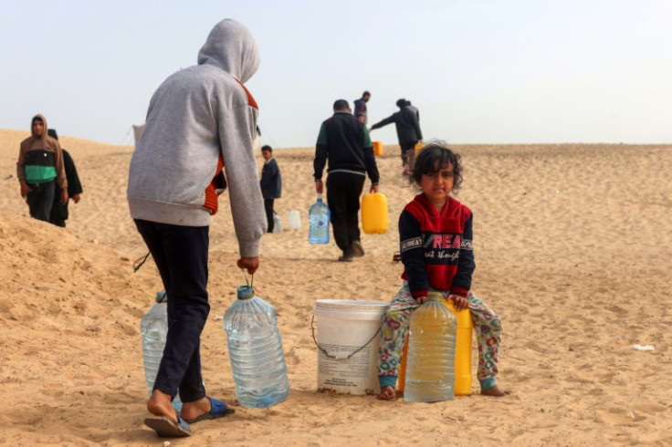 Palestinians transport water to a camp for displaced people in Rafah in the southern Gaza Strip